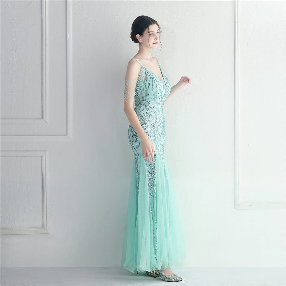 A shimmering mint green mermaid-style gown with intricate silver beading and delicate sheer fabric designed as a mesh beaded bridal wedding dinner gown.