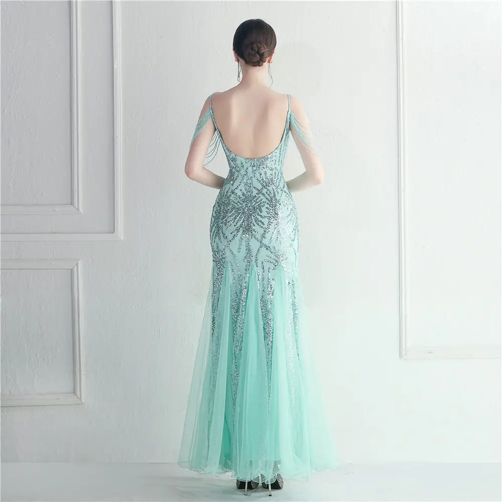 A shimmering mint green mermaid-style evening gown featuring intricate silver beading and delicate sheer tulle overlay designed as a mesh beaded bridal wedding gown for bridal wedding dinner events.