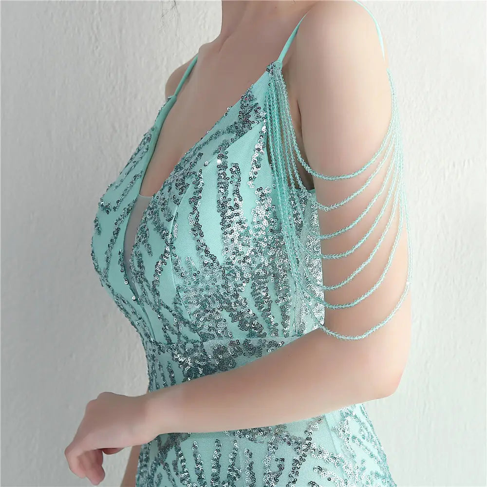A shimmering mint green evening gown with delicate shoulder chains featuring mesh beaded bridal details ideal for a bridal wedding dinner.