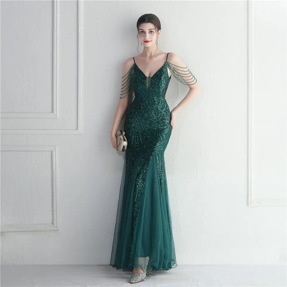 Emerald green mermaid-style evening gown with sequined bodice, sheer mesh skirt, and delicate beaded shoulder straps designed as a mesh beaded bridal wedding dinner gown.