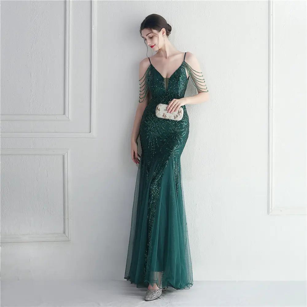 Emerald green sequined mermaid gown with sheer mesh overlay and beaded shoulder straps designed as a mesh beaded bridal wedding dinner gown.
