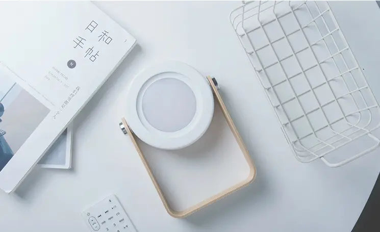 a minimalist white and light wood-framed foldable touch dimmable portable lantern night light with a soft glowing led panel for touch dimmable reading and ambient illumination