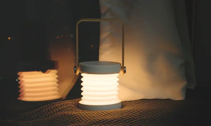 A sleek foldable touch dimmable portable lantern night light with a soft white glow and gray metallic handle designed for touch dimmable reading.