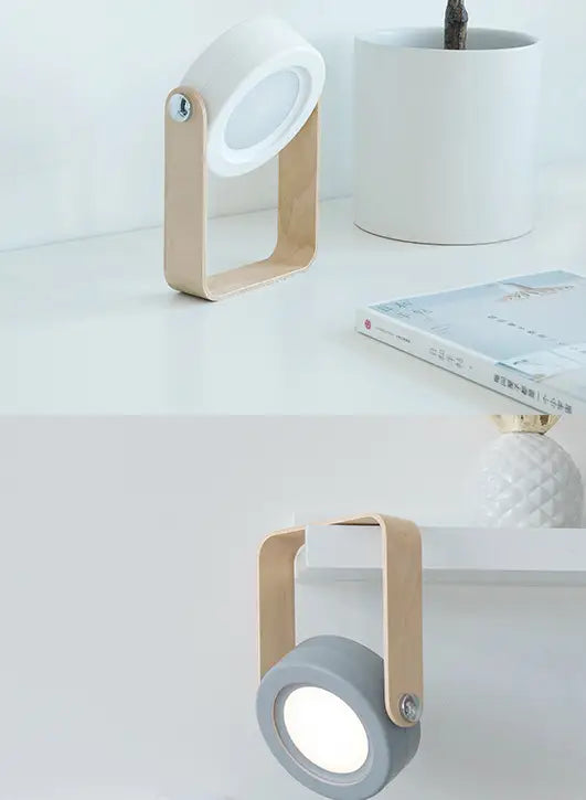 Minimalist desk lamp with a matte white circular head and light wood-finished metal frame featuring an adjustable arm for foldable touch dimmable night light and touch dimmable reading use.