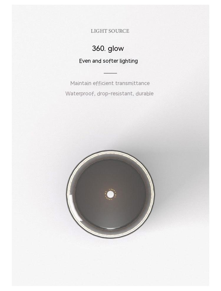 a sleek, circular rechargeable portable night light led camping light with a matte gray finish and metallic rim
