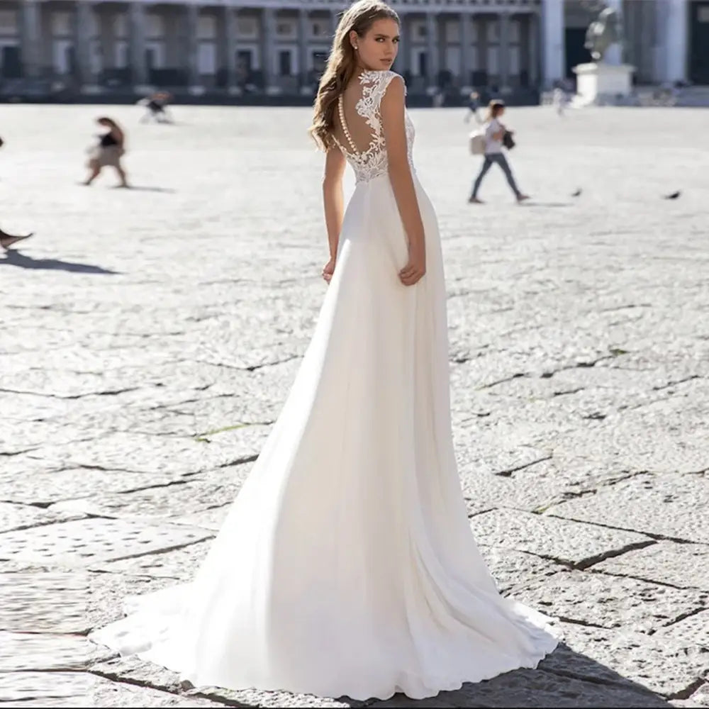 white series chiffon wedding dress with v-neck lace sleeves and intricate lace detailing along the back in a fitted silhouette
