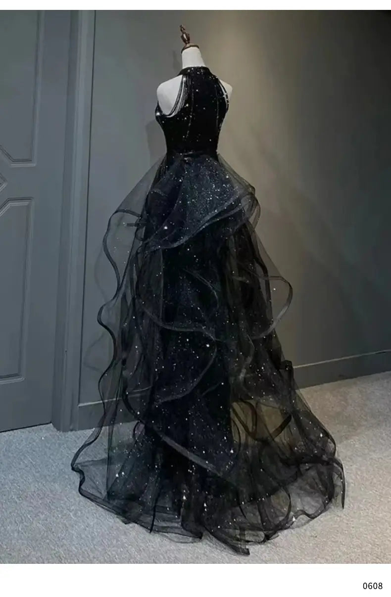 Black evening dress featuring a sequined halter bodice and layered sheer tulle skirt designed for elegant evening wear.