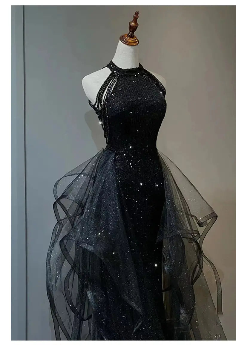 Black evening dress featuring a sequined halter design with a sheer layered tulle overlay for elegant evening wear.