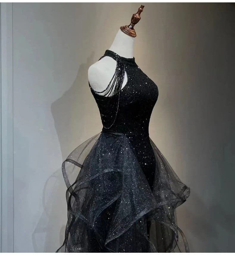 Black evening dress featuring a black sequined halter neck with beaded shoulder straps and a layered sheer tulle skirt.