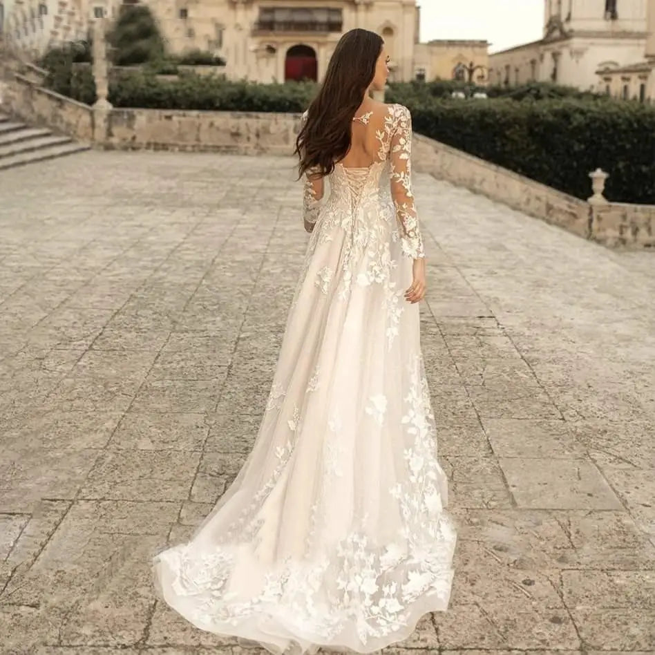 a flowing ivory long sleeve wedding dress mori style featuring intricate floral lace detailing along the sleeves and back, shown from the back side
