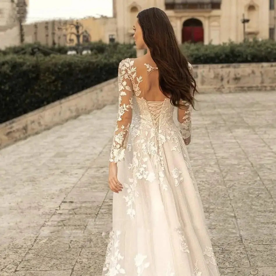 Elegant ivory long sleeve wedding dress mori style featuring intricate floral lace detailing on the back and sleeves with a flowing skirt.
