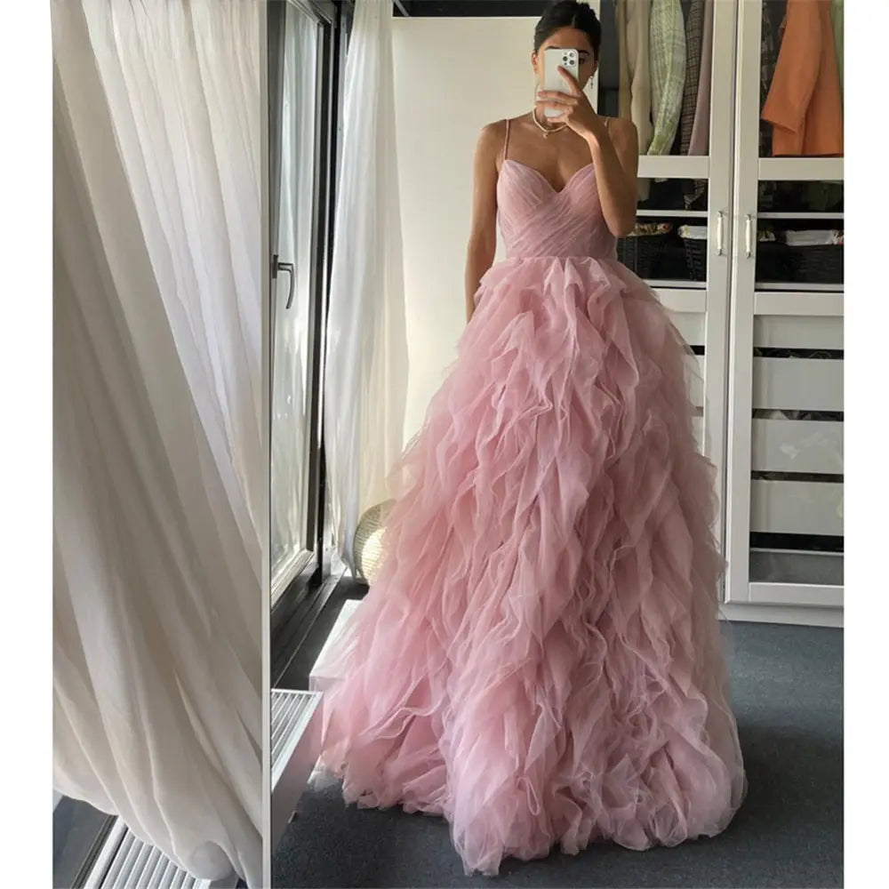 A flowing blush pink mesh long dress evening gown prom with a sweetheart neckline and layered ruffle skirt.