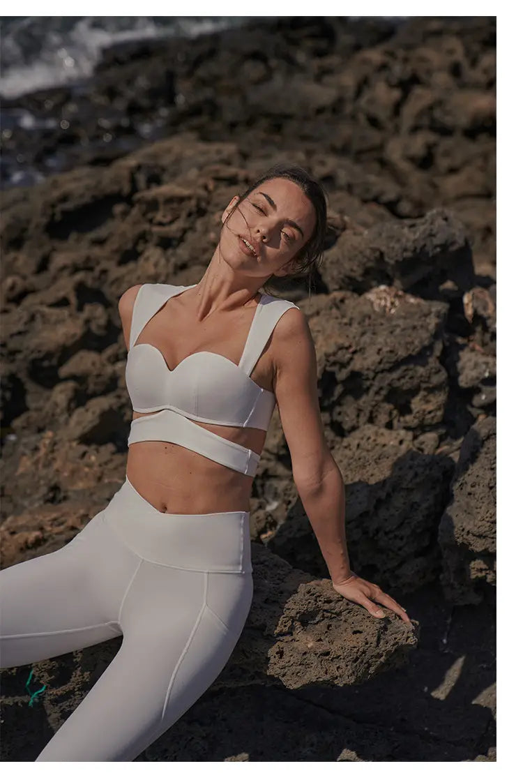 white cropped sports bra with wide shoulder straps paired with beige yoga pants and a sport coat fitness set featuring a deep black color for versatile workout and casual wear.