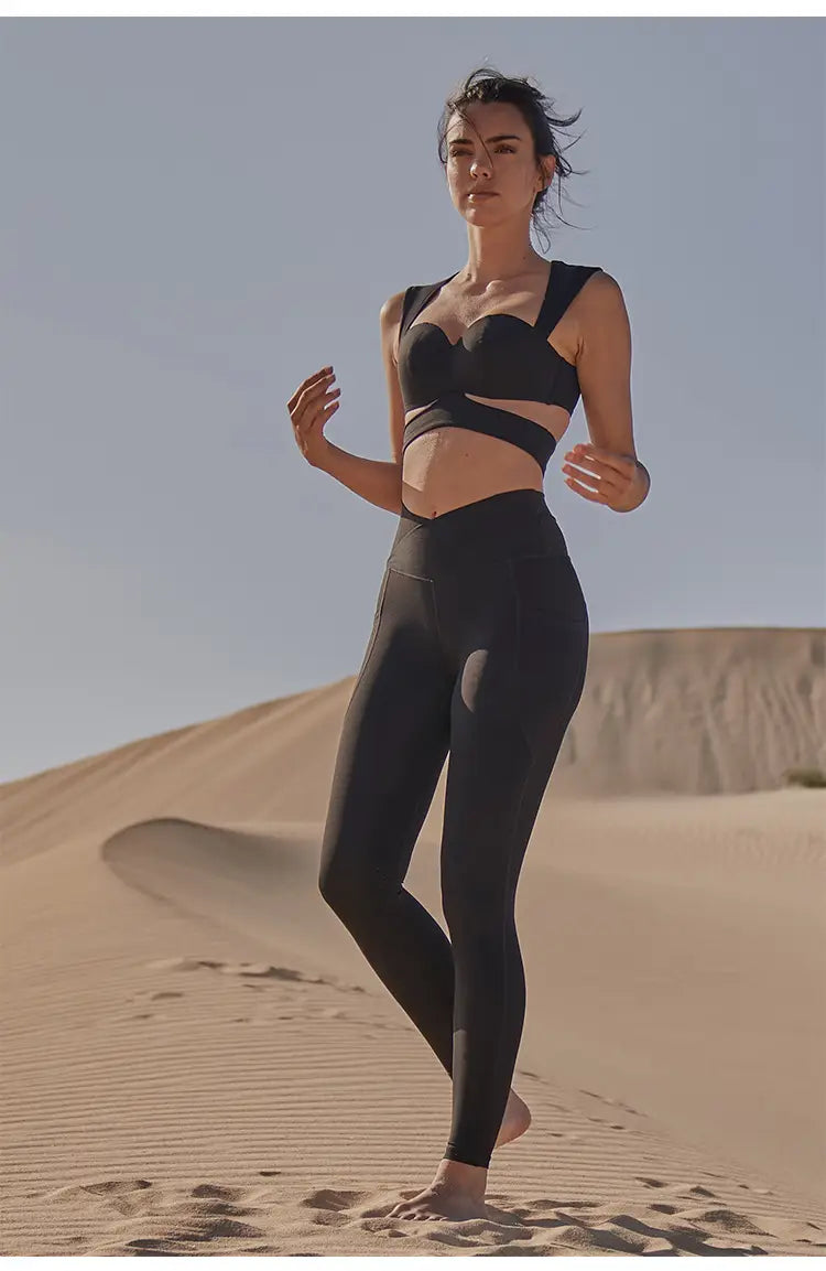 black athletic two-piece set featuring a strappy bra top and high-waisted leggings in deep black color paired with beige yoga pants and sport coat fitness set