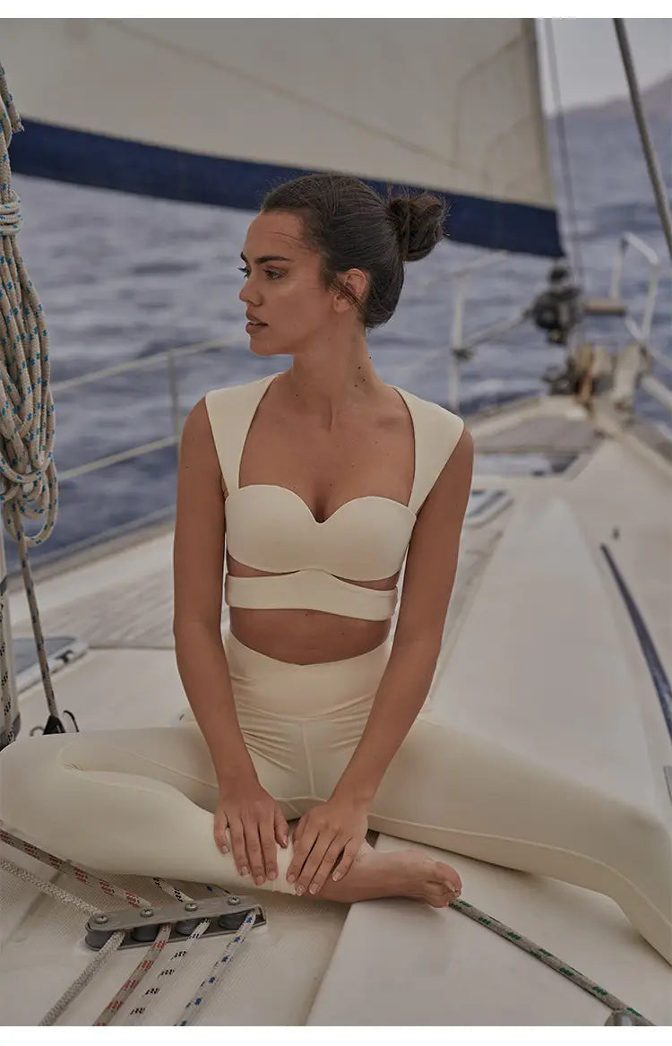 cream-colored form-fitting two-piece athletic set with cropped top and high-waisted beige yoga pants paired with a deep black color sport coat for fitness and casual wear