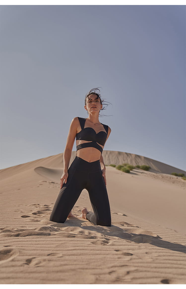 black cut-out sports bra with sleek, form-fitting design in deep black color paired with beige yoga pants and sport coat fitness set