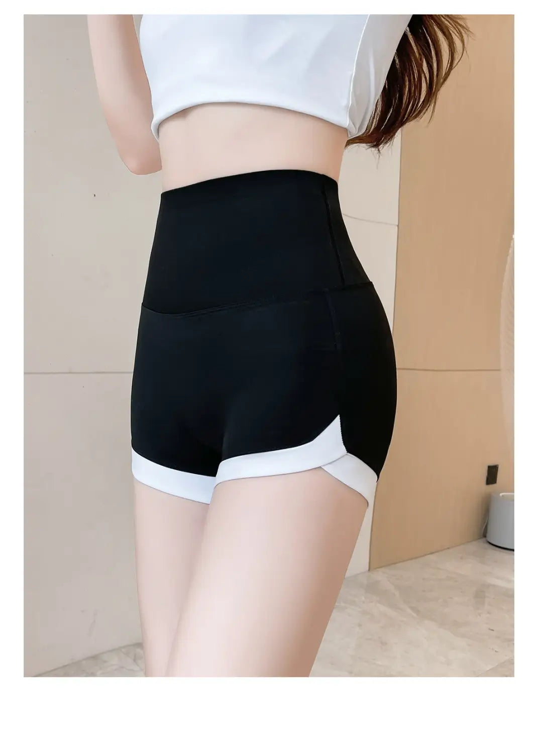 black high waisted hip lifting sports shorts with white trim along the hem and side panels designed for athletic use.