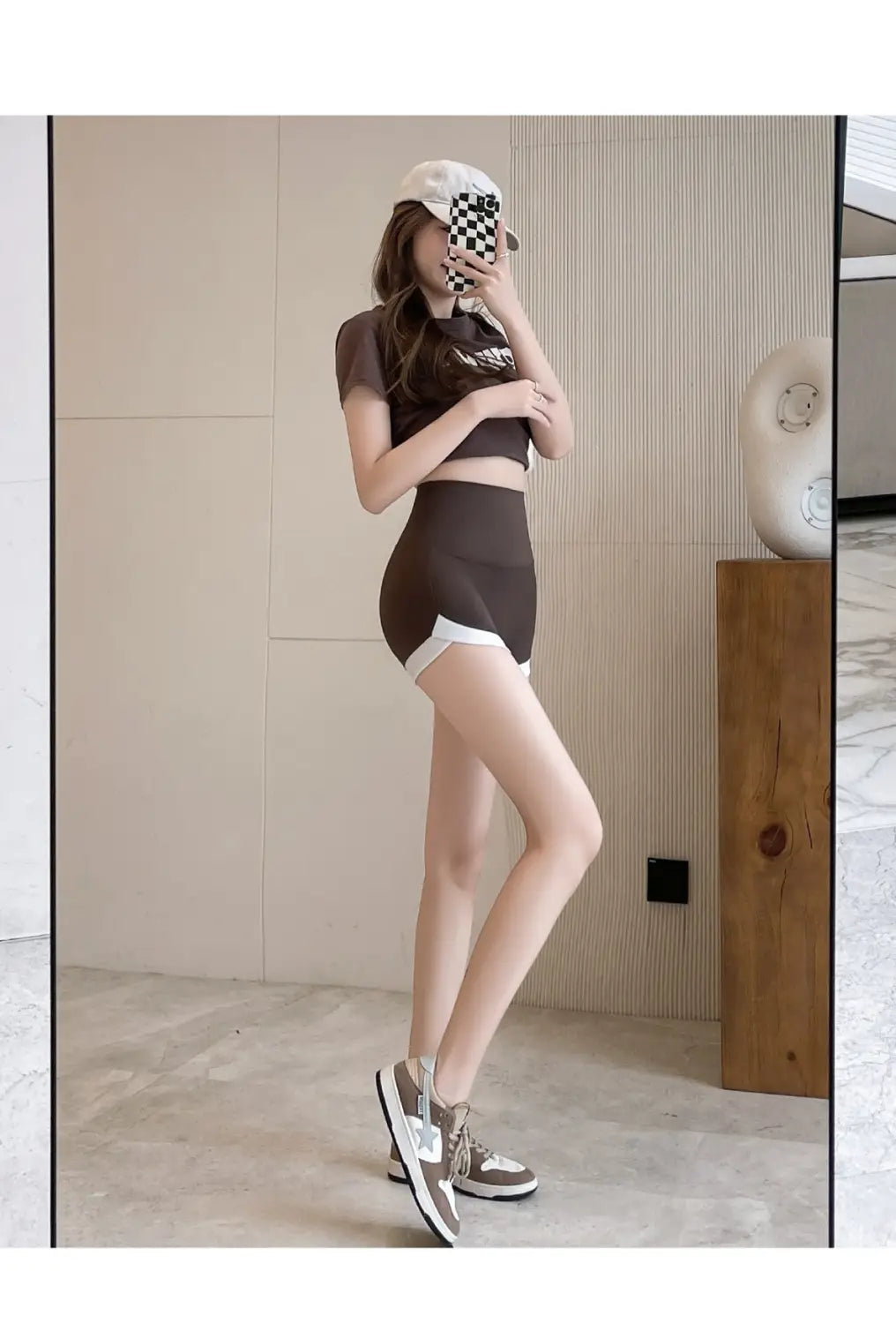 Brown cropped top with white trim and graphic print paired with brown high waisted hip lifting sports shorts designed for hip lifting and stitching yoga pants use.
