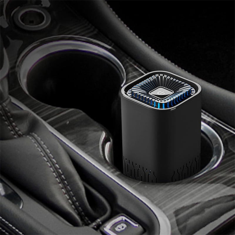 Black cylindrical portable car air purifier with a textured grille on top and a blue led light ring featuring a negative ion generator for improved air quality.