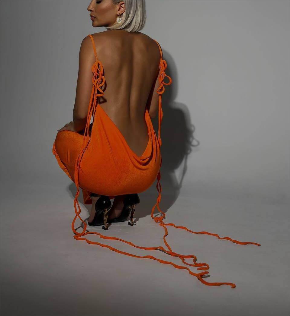 vibrant orange sleeveless slim backless dress summer gown with tied flowing ribbons at the back made of light blue satin material.
