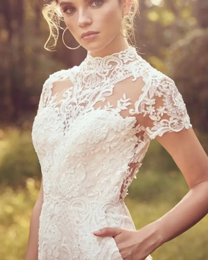 a white lace bride pants suit with intricate floral patterns and short sleeves designed for a suit wedding bridal look
