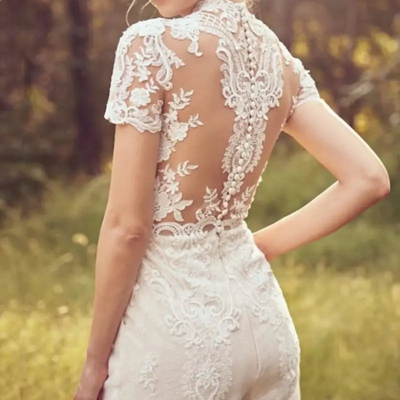 a white lace bride pants suit with intricate floral embroidery and a sheer back design for a suit wedding bridal occasion