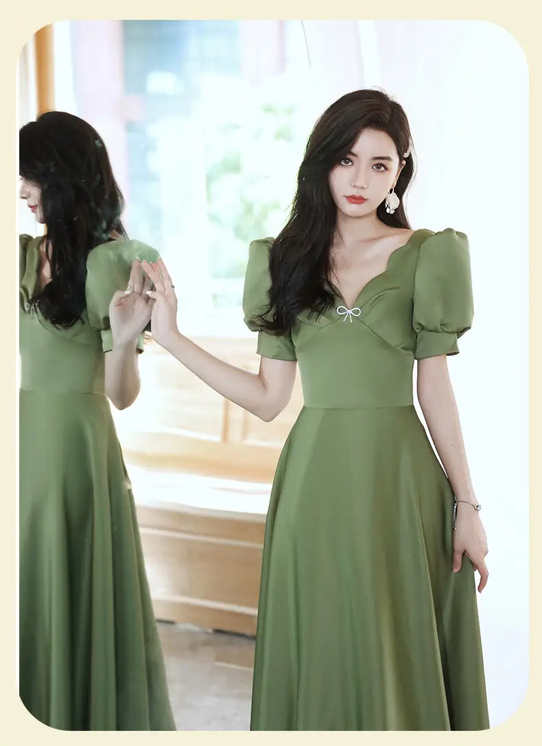 a soft avocado green sisters group satin v neck midi dress with puffed short sleeves and a delicate white bow at the neckline