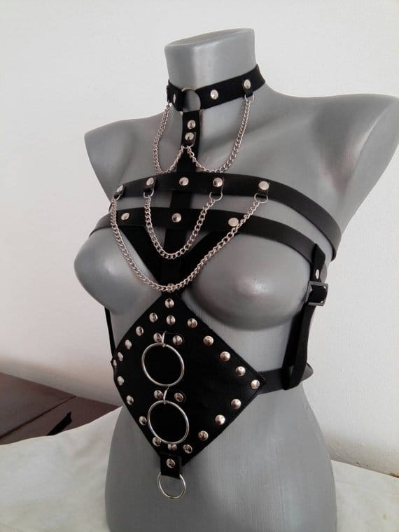 Black leather harness adorned with silver studs chains and metal rings designed as a perform dance costume accessory