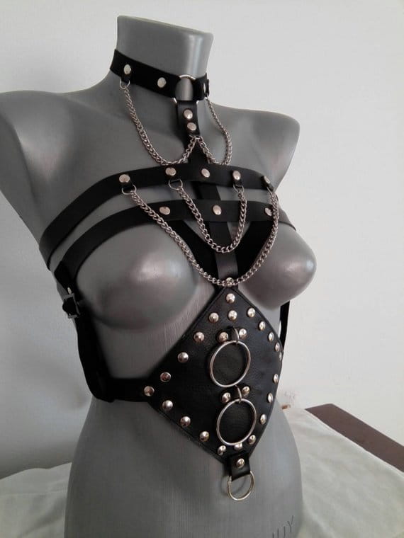 black leather harness with silver toned metal studs rings and chains designed as a studded leather perform dance costume