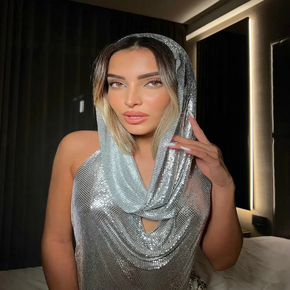 a shimmering silver mesh headscarf with a cowl neckline and cutout detail from a silver slit metal sequins two-piece set with hood