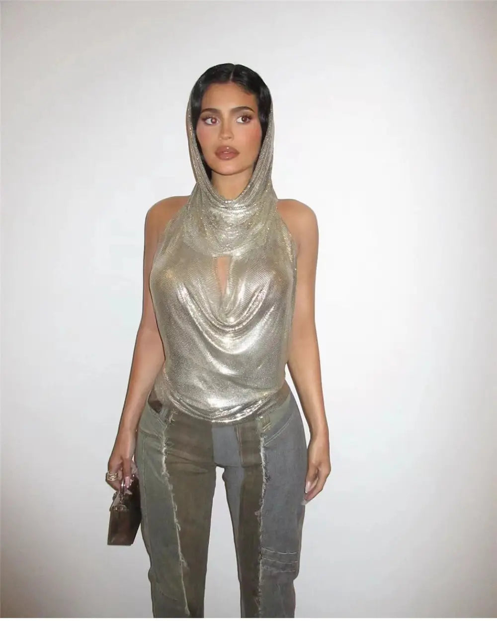 Silver shiny metallic silver hooded top with draped cowl neckline and sheer fabric from a slit metal sequins two-piece set.
