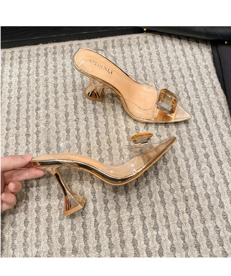 pink satin bow women’s high-heeled sandal featuring transparent gold-accented mule heels with a clear block heel and a square gemstone detail on the toe.