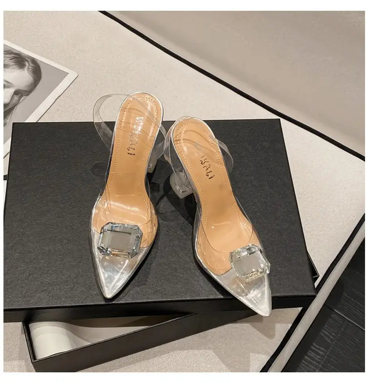 Pink satin bow women’s high-heeled sandal featuring transparent acrylic heels with a clear block heel and a large square-cut crystal embellishment at the toe.