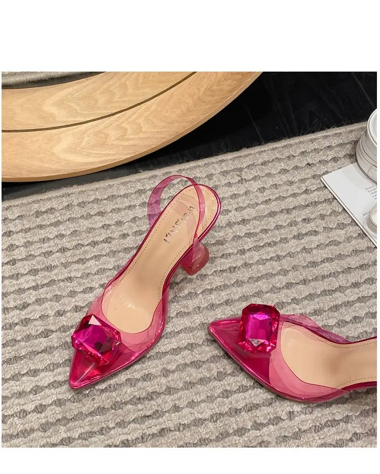 pink satin bow women’s high-heeled sandal featuring transparent high-heeled sandal design with a prominent faceted gemstone accent at the toe.