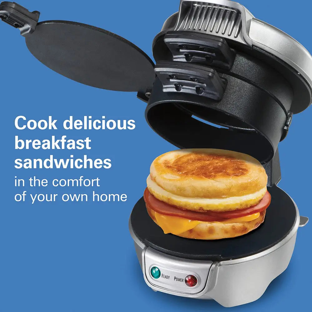 Silver and black Hamilton Beach electric hamburger maker and egg toaster displaying a golden-brown breakfast sandwich inside suitable for Royale Essence Lux use