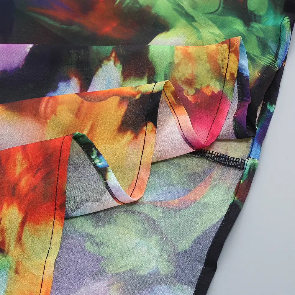 Floral v-neck split comfort casual dress featuring vibrant tie-dye fabric with swirling patterns of red, orange, green, and purple.