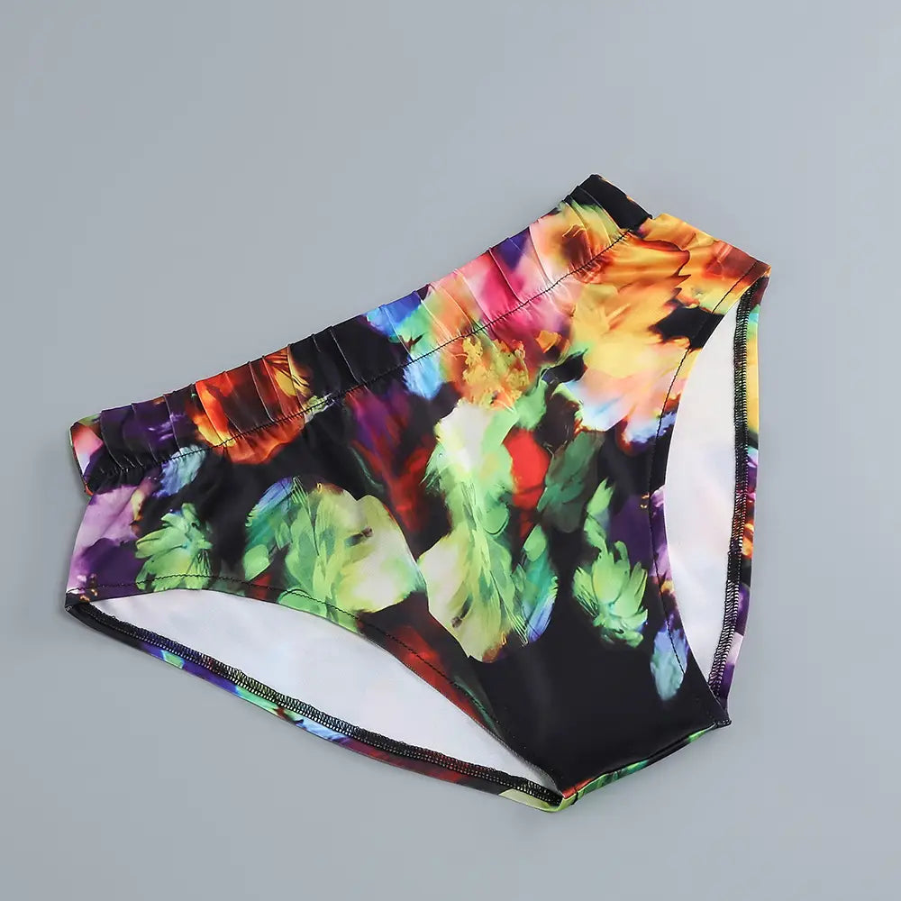 vibrant floral-patterned black swim trunks featuring colorful abstract blooms in orange green purple and blue complement the casual dress split comfort style with a v-neck split comfort design