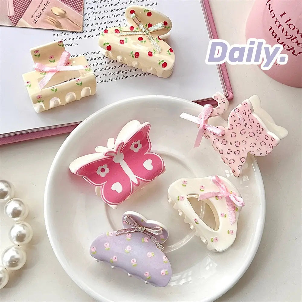 Pink butterfly floral small jaw clip with bow features pastel-colored butterfly-shaped hair clips with floral and polka dot patterns and delicate pink bows designed for a secure jaw clip grip.