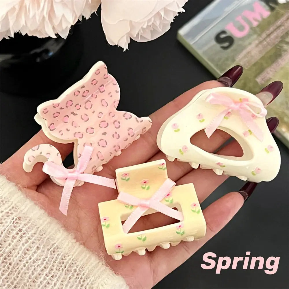 pastel-colored small jaw clips with floral and leopard print designs featuring delicate pink ribbon bows designed as jaw clip grips for secure hair styling.
