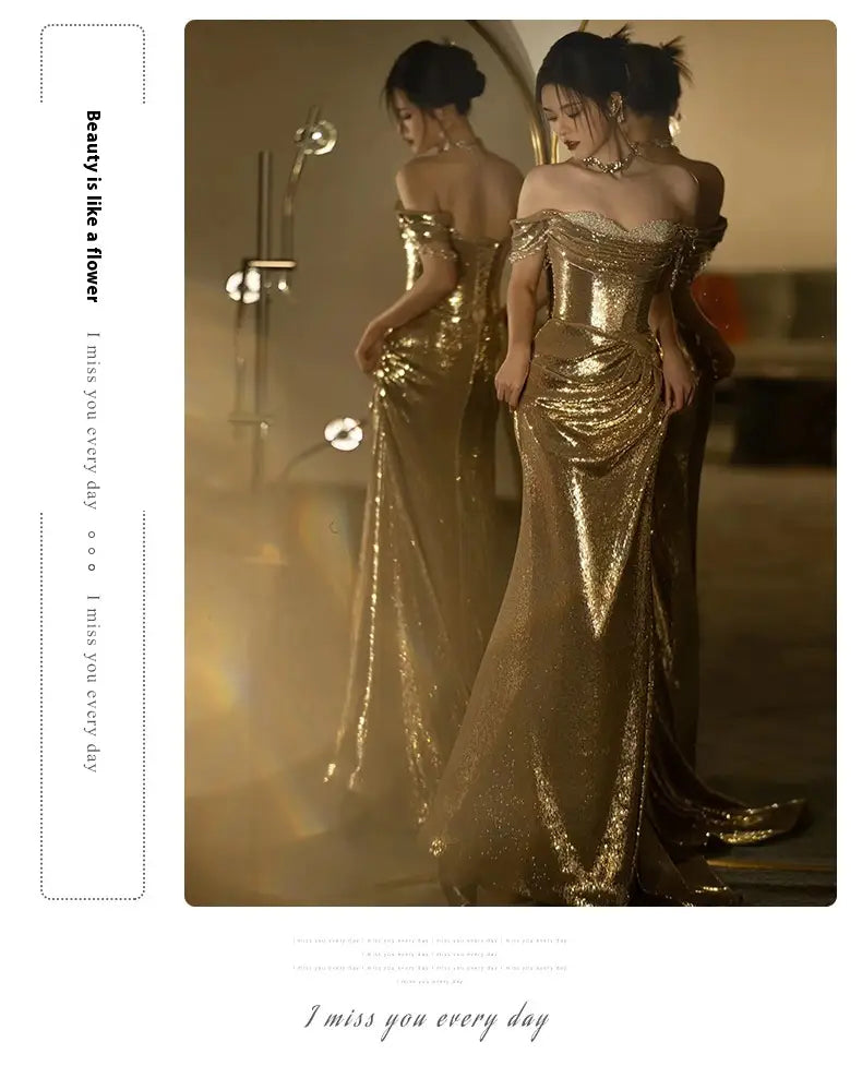 A shimmering gold sequined off-shoulder dress bridal fishtail with a fitted bodice and flowing train suitable as a gold evening dress or toast dress bridal.