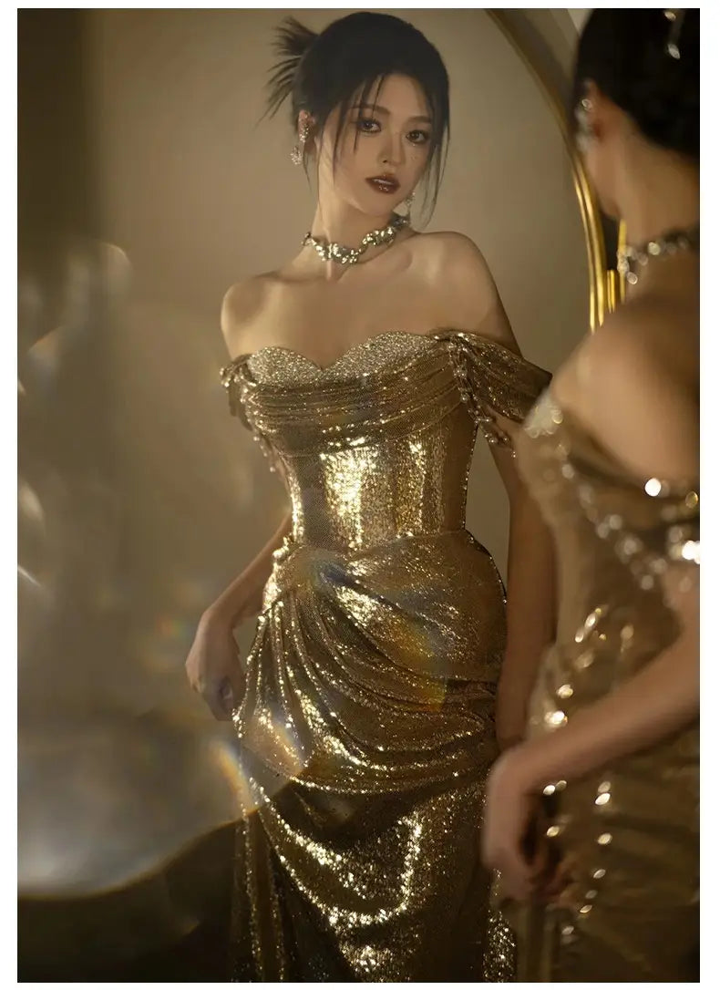 A shimmering gold sequined off-shoulder dress bridal fishtail featuring a fitted corset bodice and flowing skirt ideal as a gold evening dress or toast dress bridal.