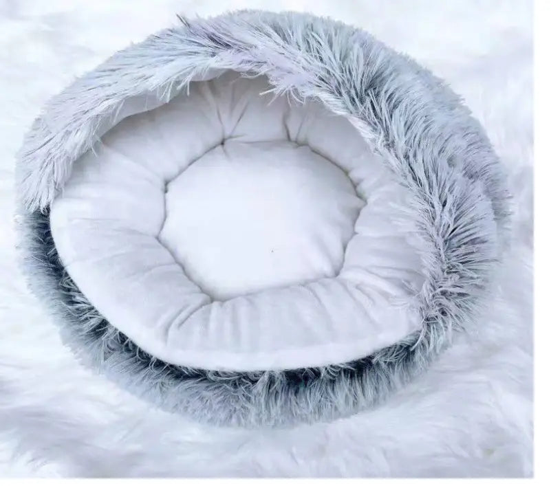 a cozy round plush warm cat bed pet with a gray faux fur exterior and a soft white cushioned interior designed as a bed pet.