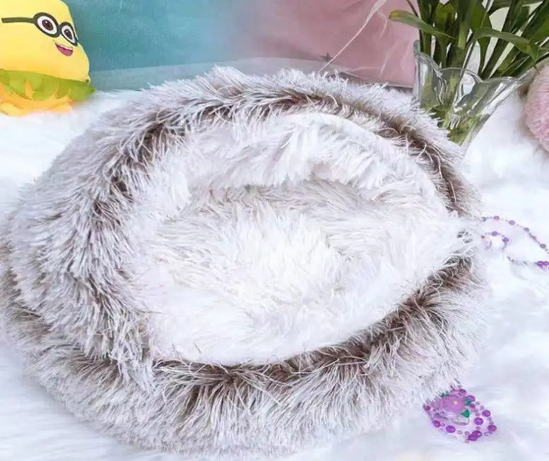 Fluffy gray and white faux fur round plush warm cat bed pet with a cozy circular design for comfort.