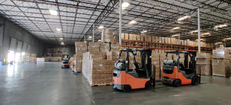two orange toyota forklifts parked side by side in a warehouse alongside a pink kiss stainless steel handle straw insulated tumbler designed to prevent stainless steel spill and maintain beverage temperature