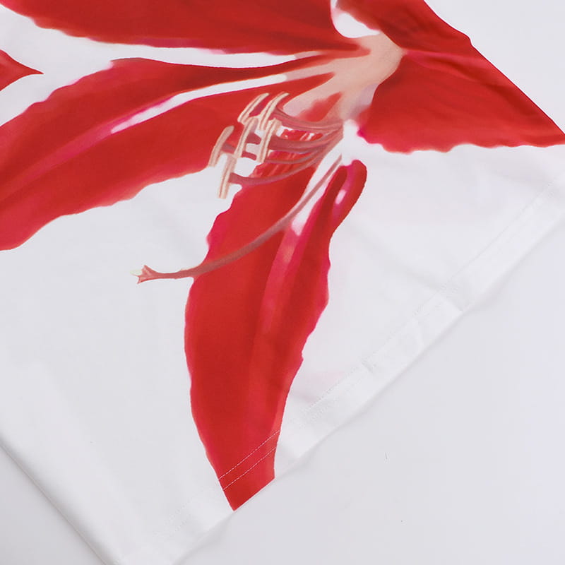 white fabric featuring bold vibrant red floral print with delicate gold accents on the center of a pink floral american style flower strap dress