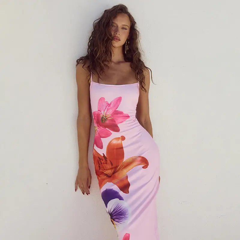 A flowing pink floral american style flower strap dress featuring vibrant lily and pansy motifs with spaghetti straps.