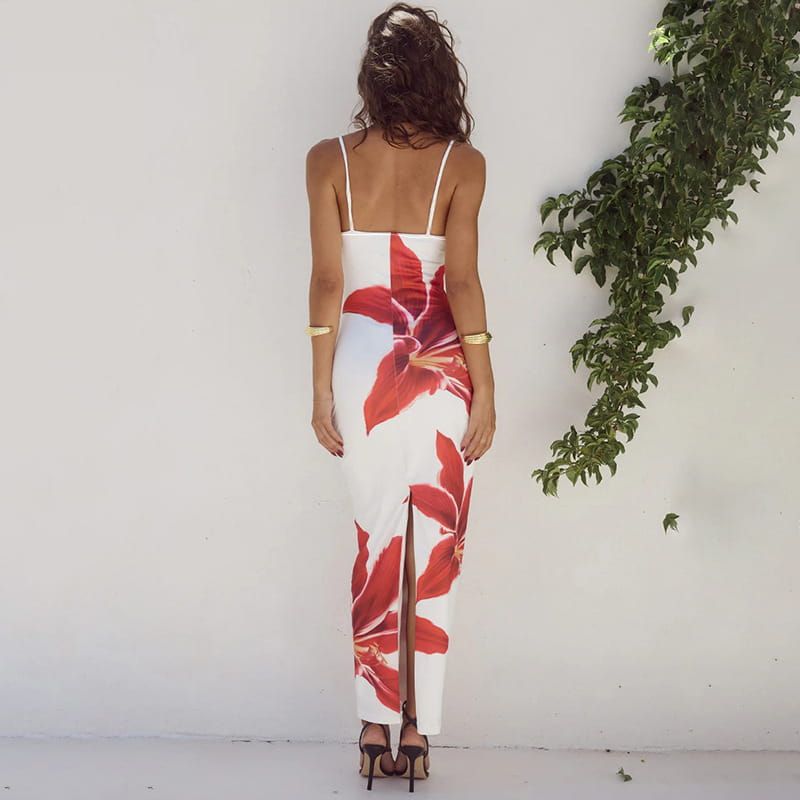 A white sleeveless maxi flower strap dress with bold red american style flower prints and a front slit featuring thin spaghetti straps.