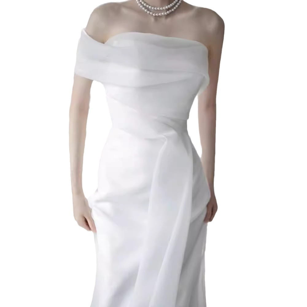 A flowing white satin off-shoulder wedding dress with a fitted bodice and draped fabric designed as a light wedding dress for the bride.