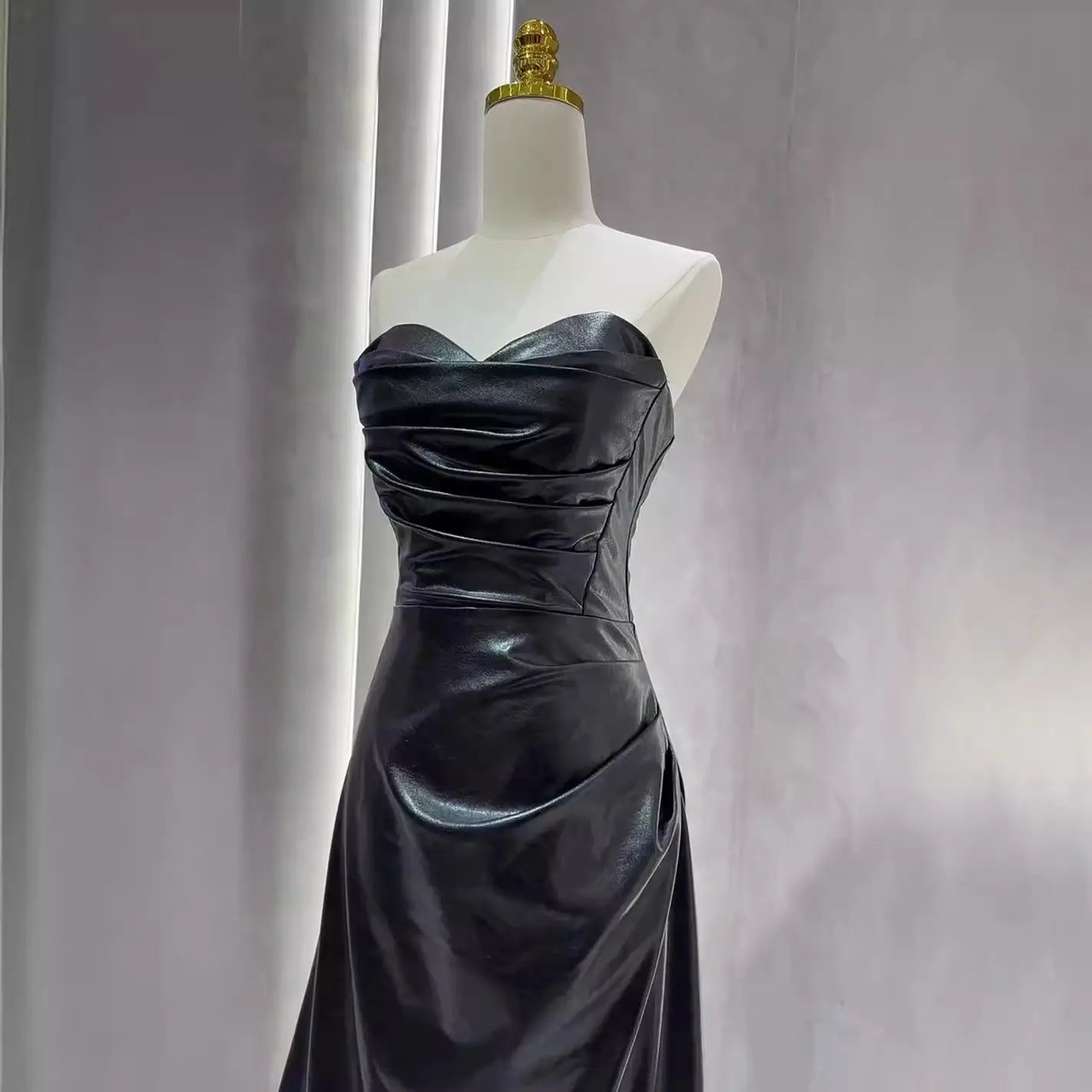 black satin strapless gown with fitted bodice and flowing skirt paired with a burgundy leather skirt evening gown with sleeves for a sophisticated skirt evening gown look