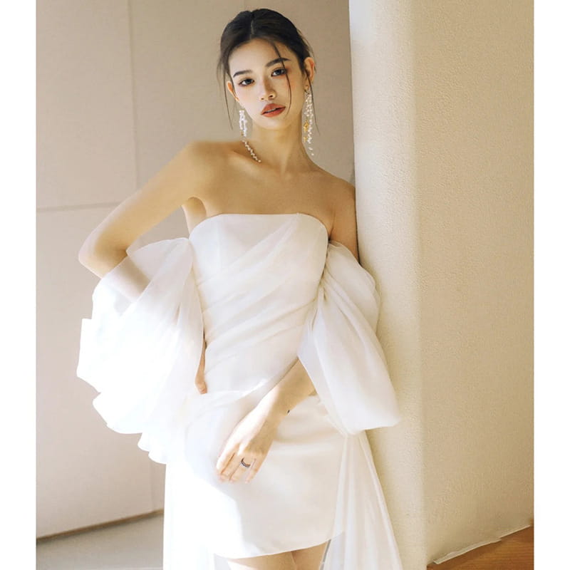 White satin strapless mini wedding dress with voluminous ruffled sleeves and train designed as a light wedding dress for small light wedding occasions